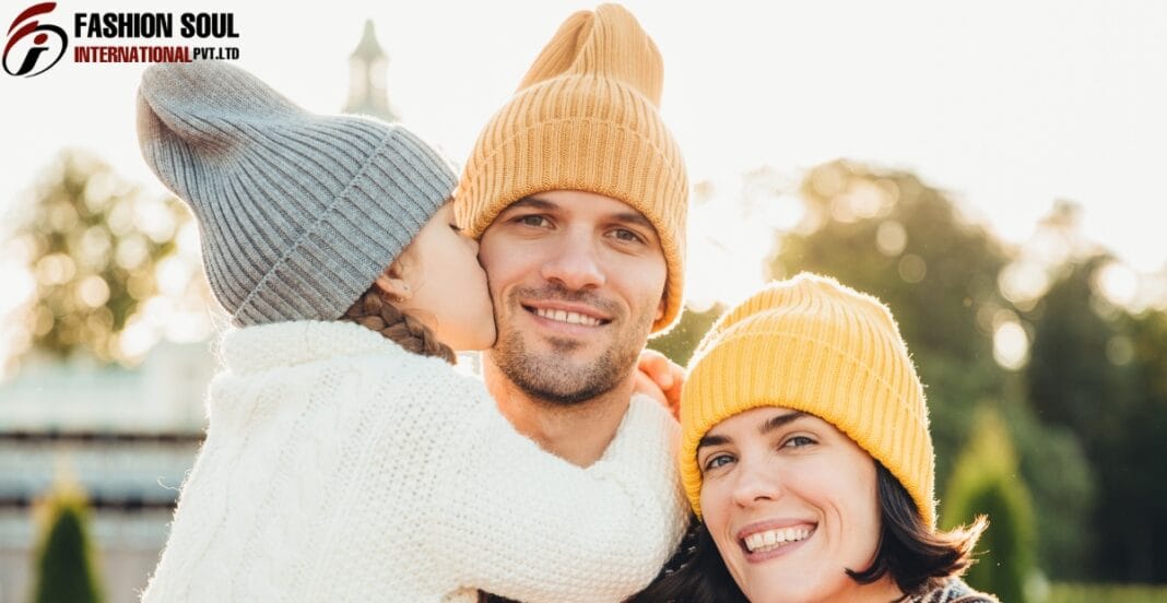 Happy family wearing colorful personalized knit hats outdoors on a sunny day