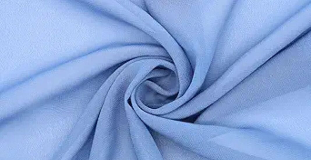 Light blue fabric twisted into a spiral pattern, showing a soft and smooth texture.