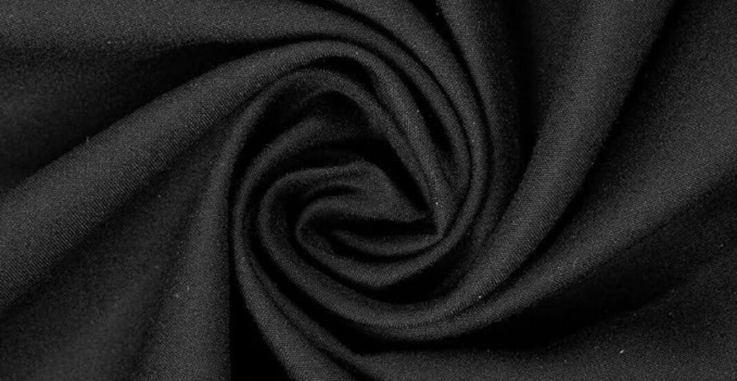 Close-up of black fabric with a smooth texture, twisted into a spiral pattern.