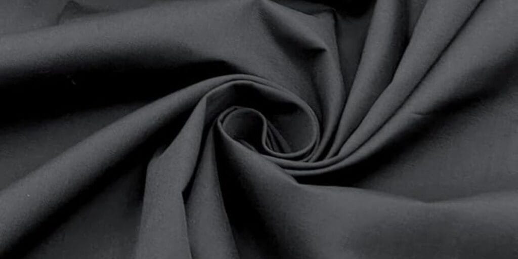 Black fabric with a soft texture, gathered in a spiral pattern.