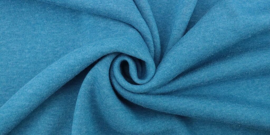 Close-up of twisted blue fabric, showcasing soft texture and smooth surface.