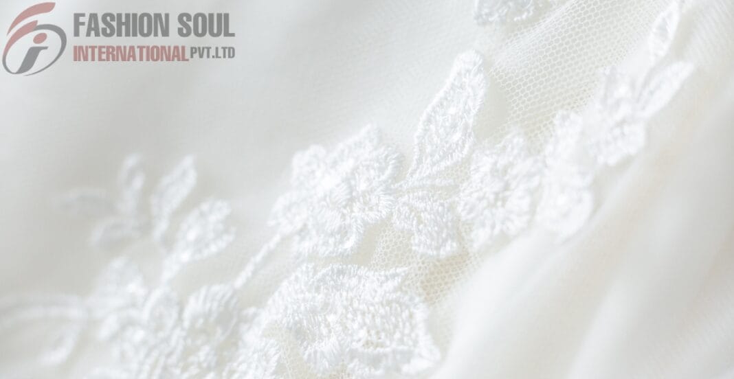 Close-up of delicate white linen fabric with floral embroidery by Fashion Soul International Pvt. Ltd.