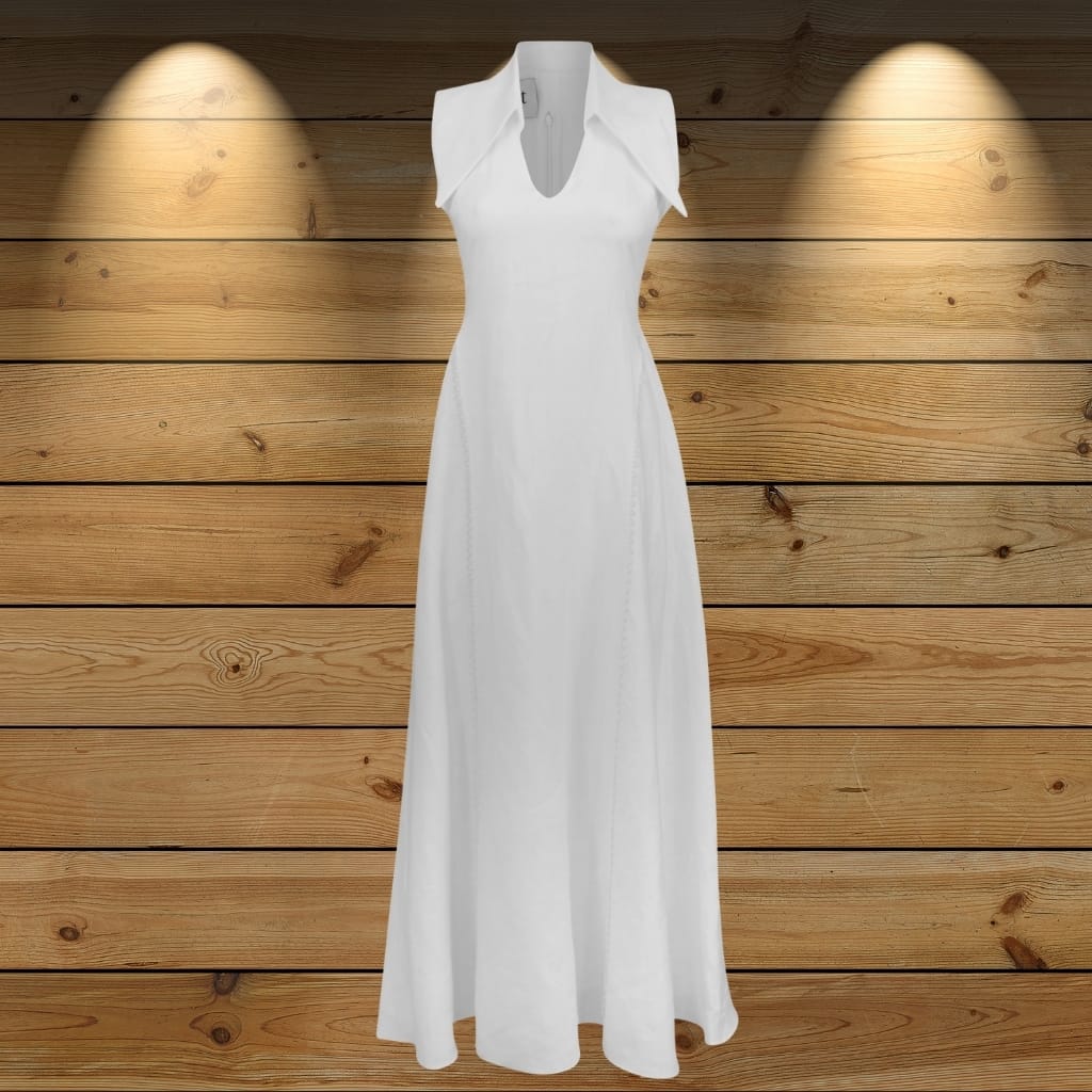 A long, elegant white dress displayed against a wooden background illuminated by two spotlights.