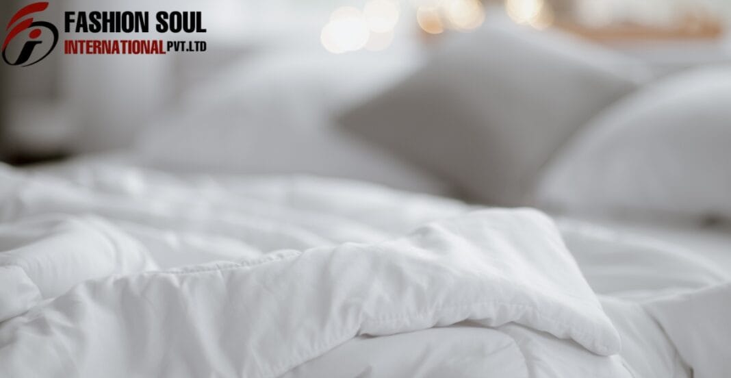 A neatly made bed with white pillows and bedding, with a blurred background and a logo in the upper left corner reading 