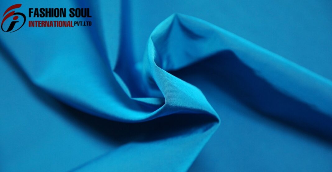 Close-up image of folded blue fabric with a logo in the top left corner that reads 