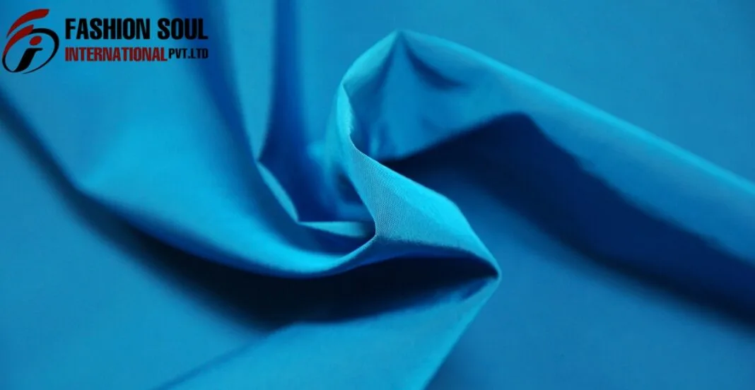 cellulosic fiber Close-up image of folded blue fabric with a logo in the top left corner that reads