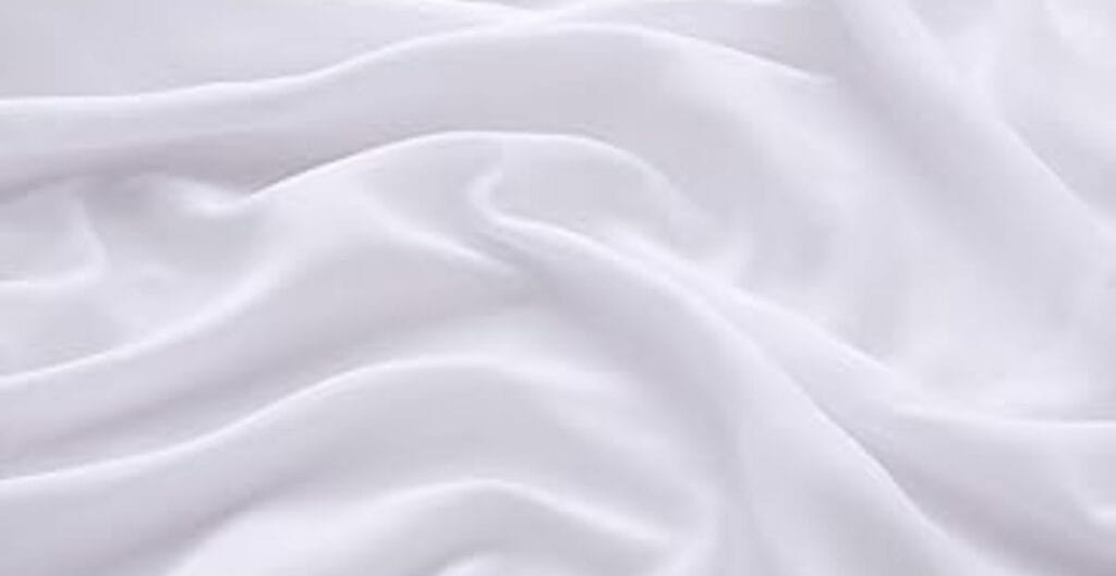 Soft white fabric with gentle folds and flowing drape.