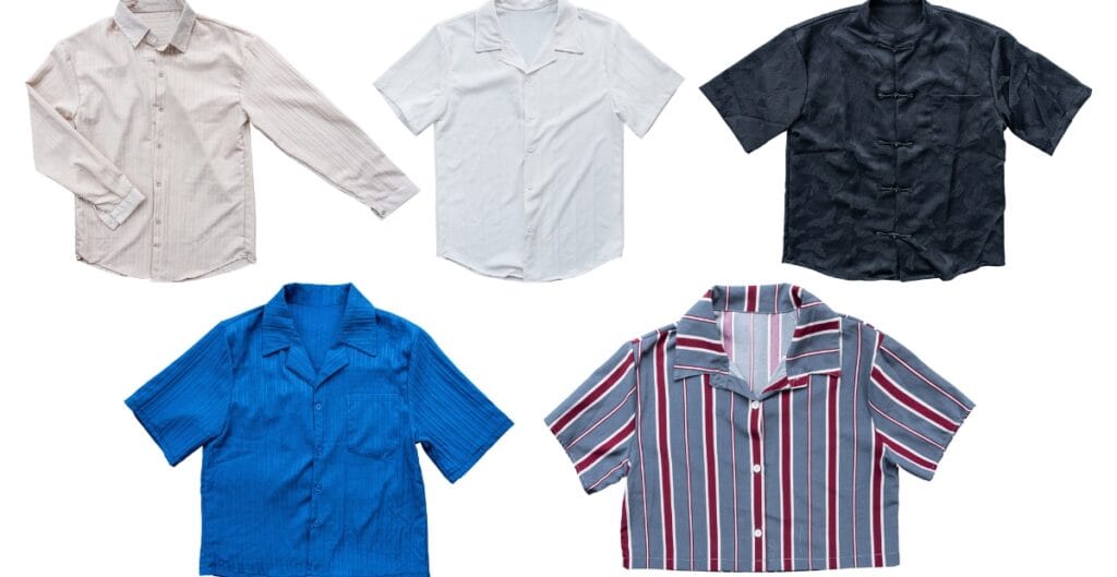 A collection of five diverse short-sleeve button-up shirts in various colors and patterns: a light pink striped shirt, a plain white shirt, a black shirt with a subtle pattern, a solid blue shirt with a ribbed texture, and a gray shirt with vertical red, white, and blue stripes.