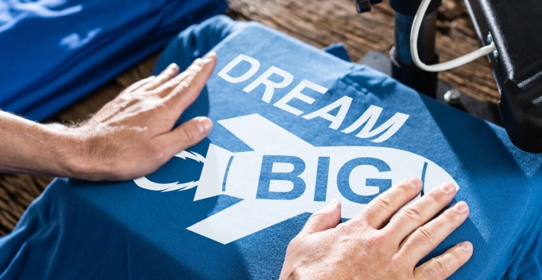 Hands resting on a blue company T-shirt with the words 