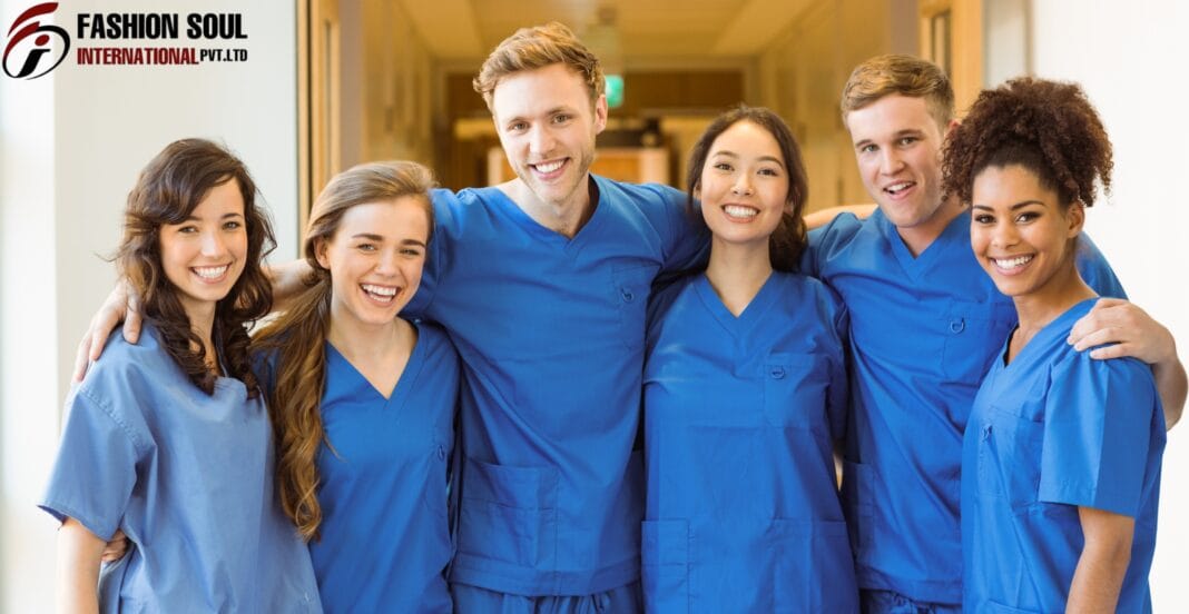 A diverse group of six healthcare professionals wearing blue scrubs, smiling and standing close together in a hospital corridor.