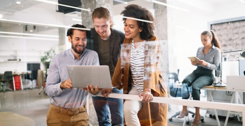 Team members around a conference table discussing the challenges of implementing a company uniform program, including budgeting, sourcing, sizing, and employee acceptance.