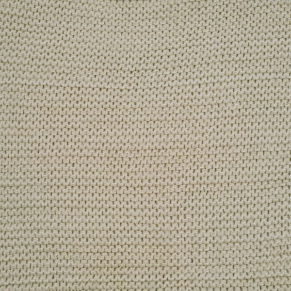 A close-up view of beige knit fabric with small interlocking loops, showing a uniform, textured surface.
