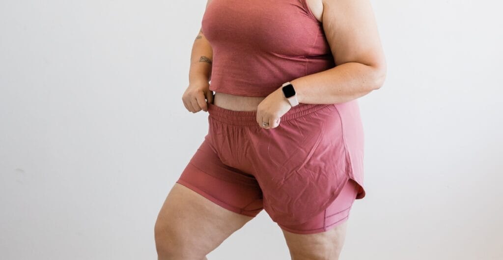 Woman in plus size lycra shorts and a crop top, confidently walking and showing off her stylish outfit