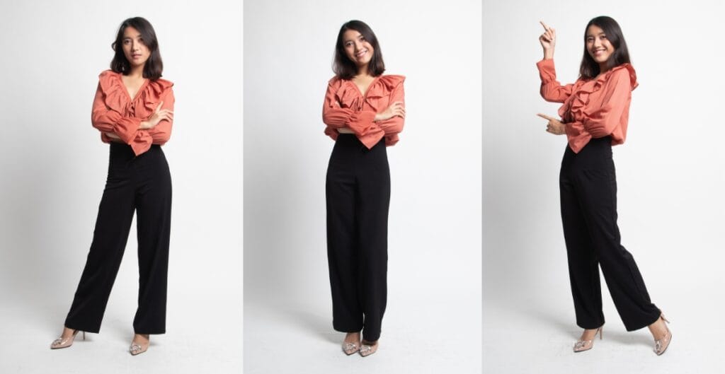 A woman wearing a stylish blouse and high-waisted pants, perfect clothes for short-waisted women