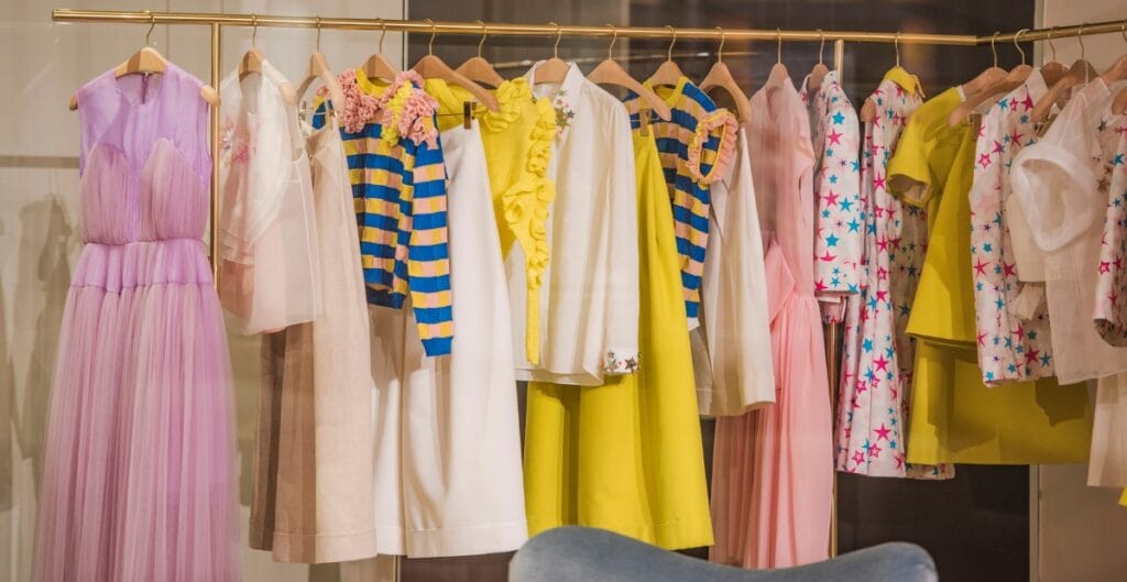 isplay of colorful and cute fashion dresses hanging neatly, showcasing bright and fun styles