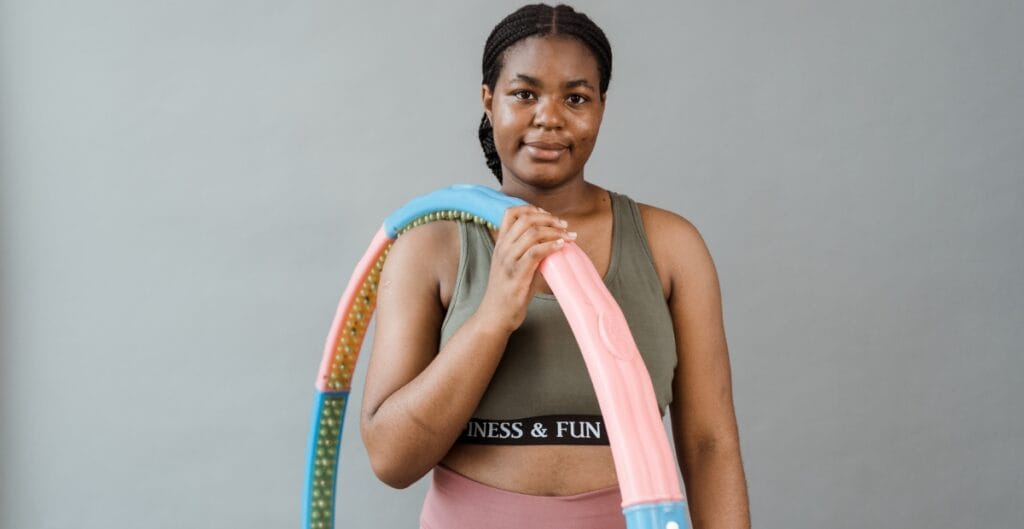 Woman wearing a large sports bra and holding a hula hoop, promoting fitness and comfort