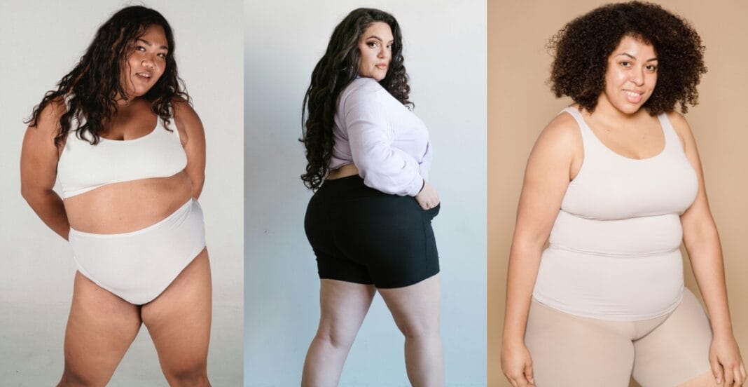 Group of women modeling neutral plus size active shorts and tank tops with body-positive energy.