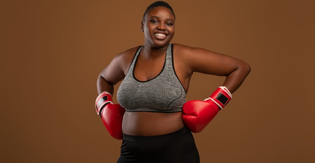 Strong and Stylish in Plus Size Boxers and Boxing Gear Smiling woman in athletic gear with red boxing gloves, standing strong and proud, highlighting comfort and support with plus size boxers