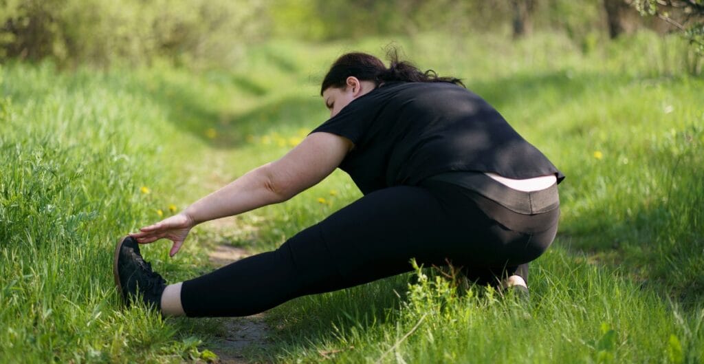 Plus size woman stretching outdoors in comfortable fitness leggings, perfect for exercise and fitness activities