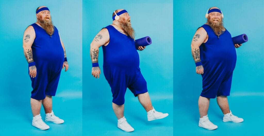 Person in blue activewear, including plus size yoga shorts, stretching with a yoga mat