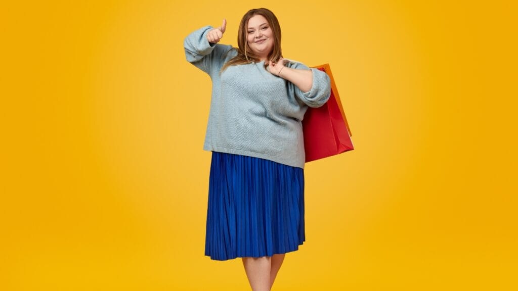 A plus-size woman posing confidently with shopping bags, ready to showcase her new fashionable look, demonstrating the power of inclusive fashion.