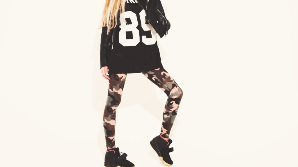 Model wearing camouflage logo leggings and a sporty oversized black shirt, creating a chic street-style look
