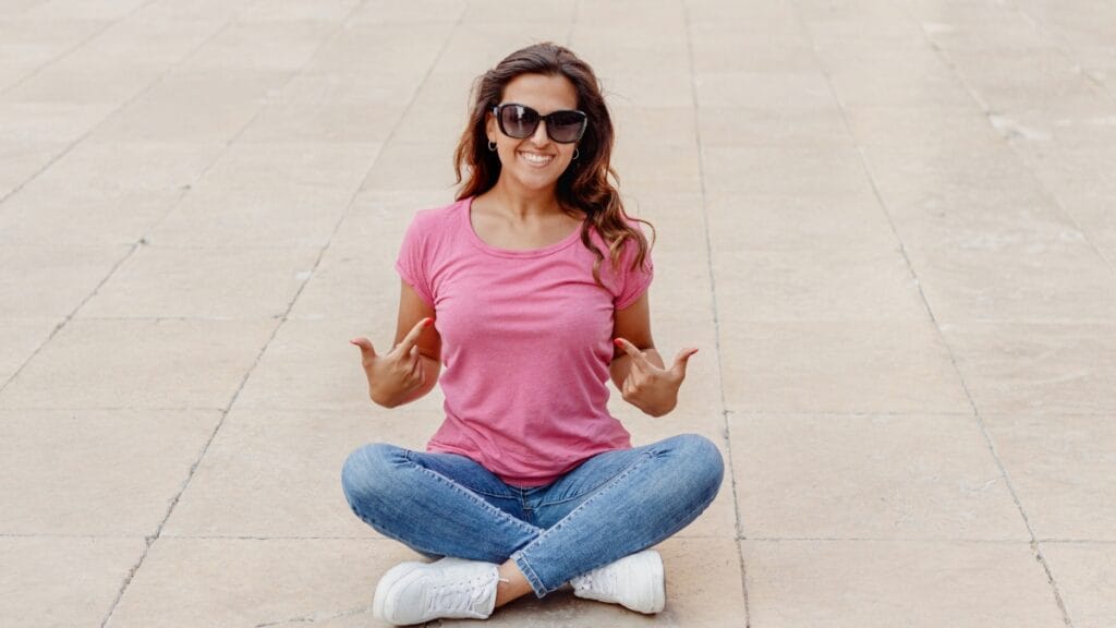 Woman sitting and pointing at her long babydoll top