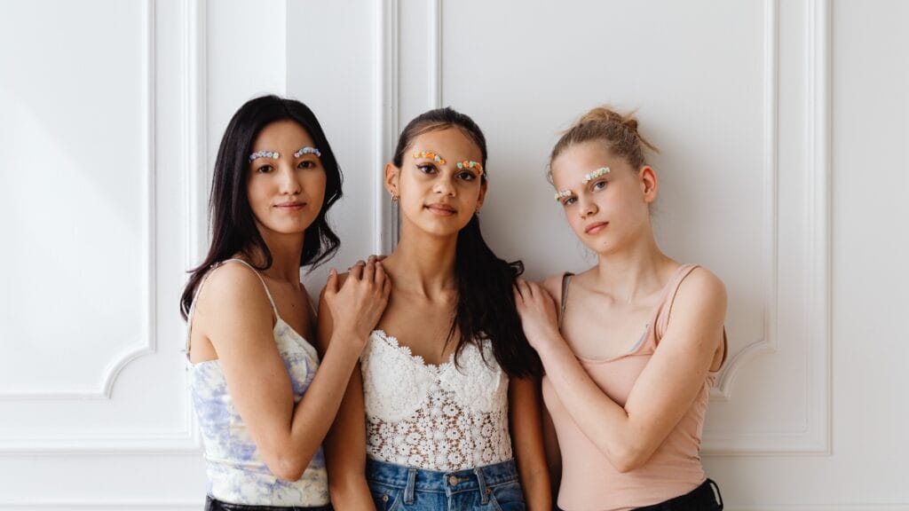 Three women wearing trendy long babydoll tops with unique designs