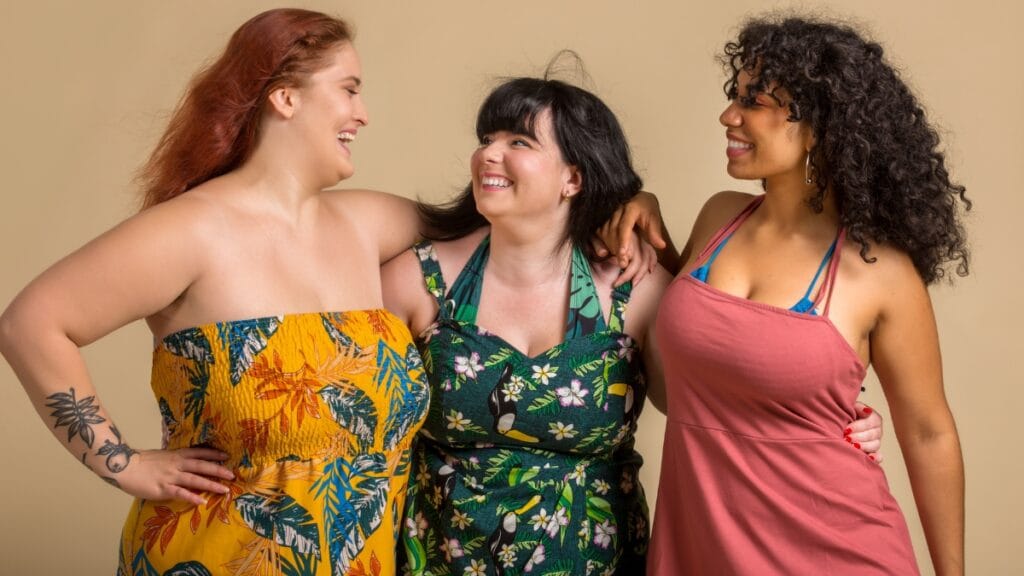 Plus-size women smiling and wearing vibrant summer dresses.
