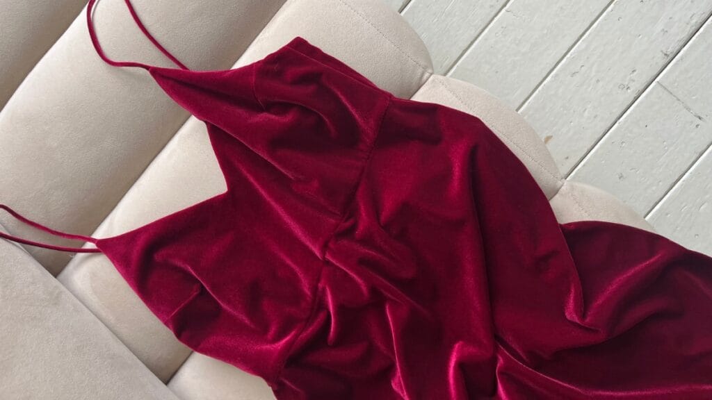 Red plus size velvet dress laid out on a white wooden floor