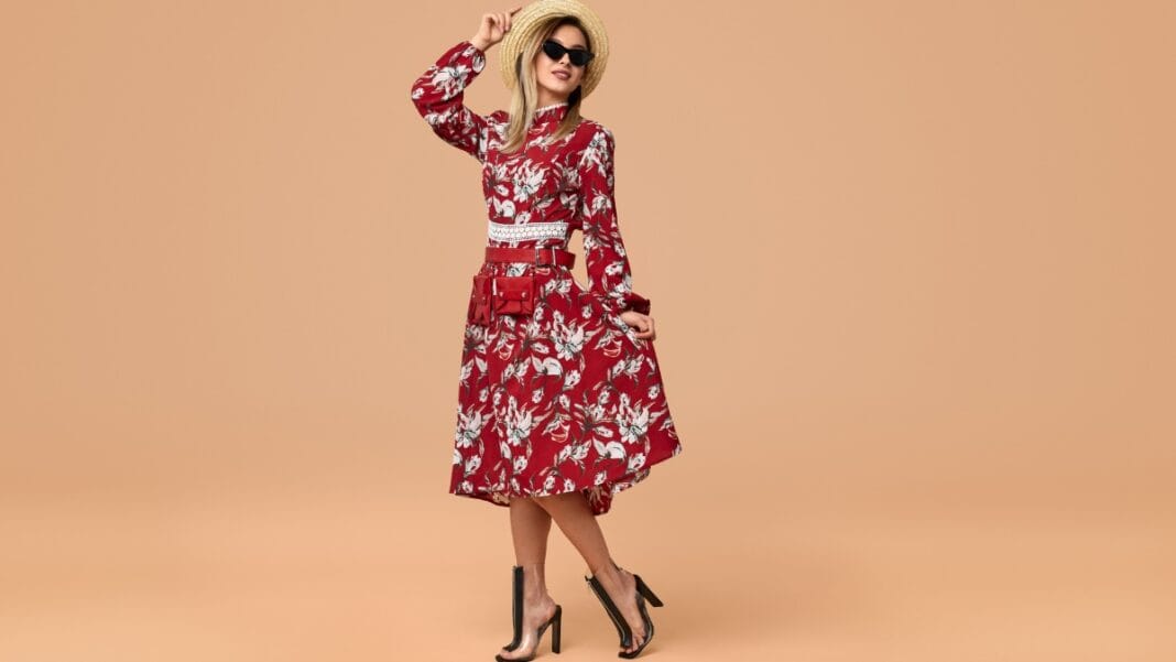 Woman in a red sexy midi dress posing confidently against a plain background