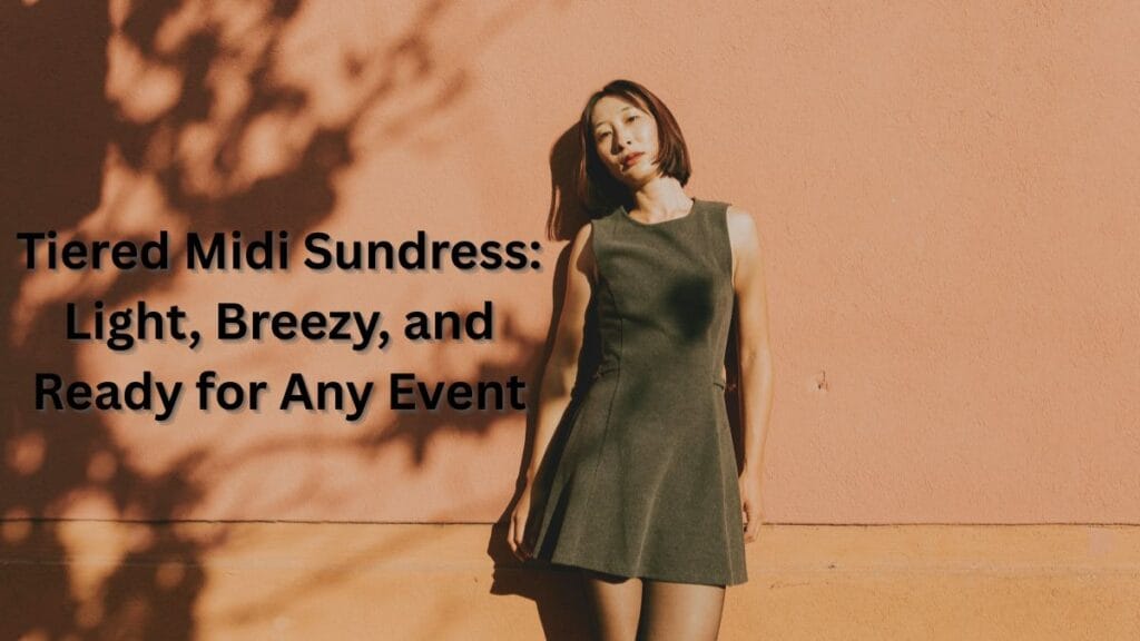 Woman wearing a sleeveless tiered midi sundress, standing against a warm-toned wall, showcasing a light and breezy warm-weather outfit.