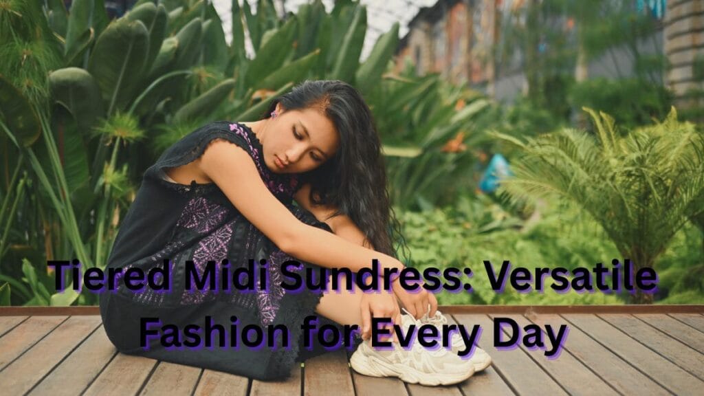 Young woman wearing a tiered midi sundress, sitting on a wooden platform surrounded by greenery, showcasing a relaxed yet stylish look.