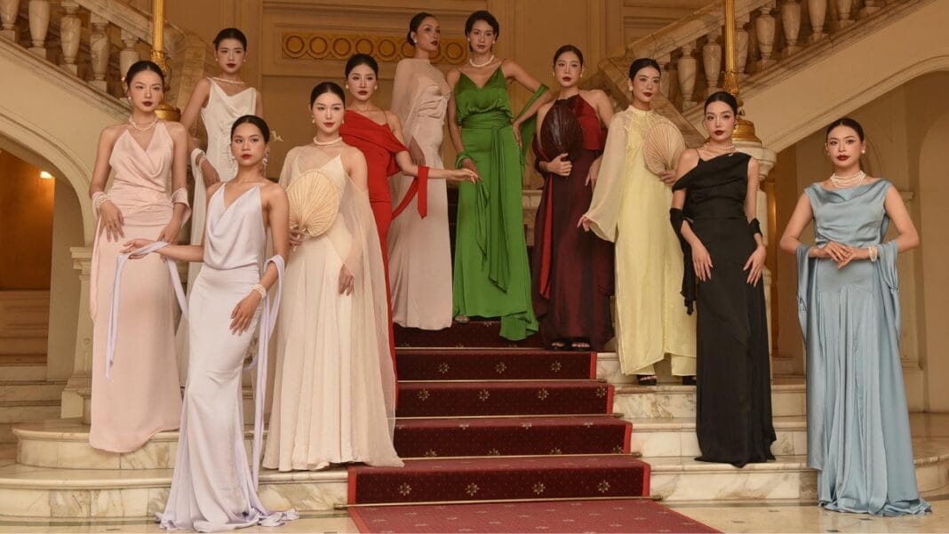 Group of women in elegant ball gown dresses showcasing various colors and styles, standing on a grand staircase