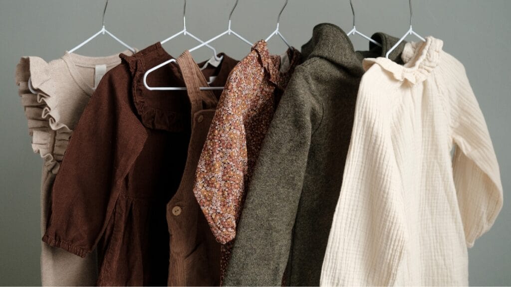 Clothes for 9-year-olds hanging on hangers, showcasing a variety of dresses and outerwear