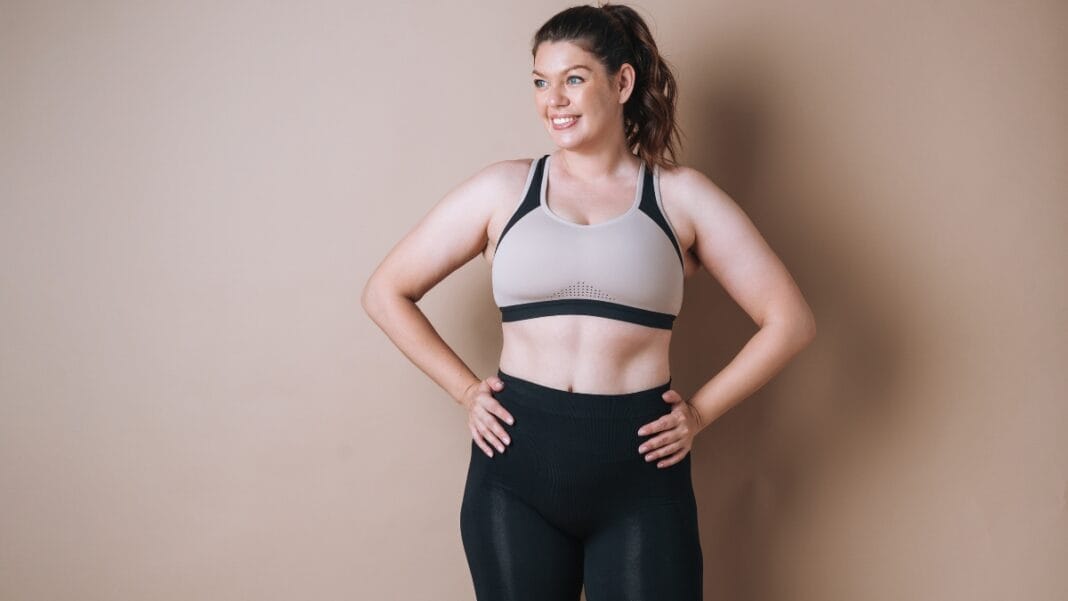 Full figured woman wearing a beige and black sports bra for active workouts