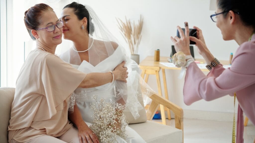 Mother of bride plus size hugging bride in wedding dress, emotional moment captured