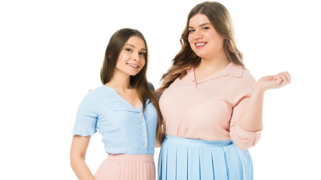A woman in a light blue shirt and pink skirt, smiling and posing, perfect outfit for short fat ladies