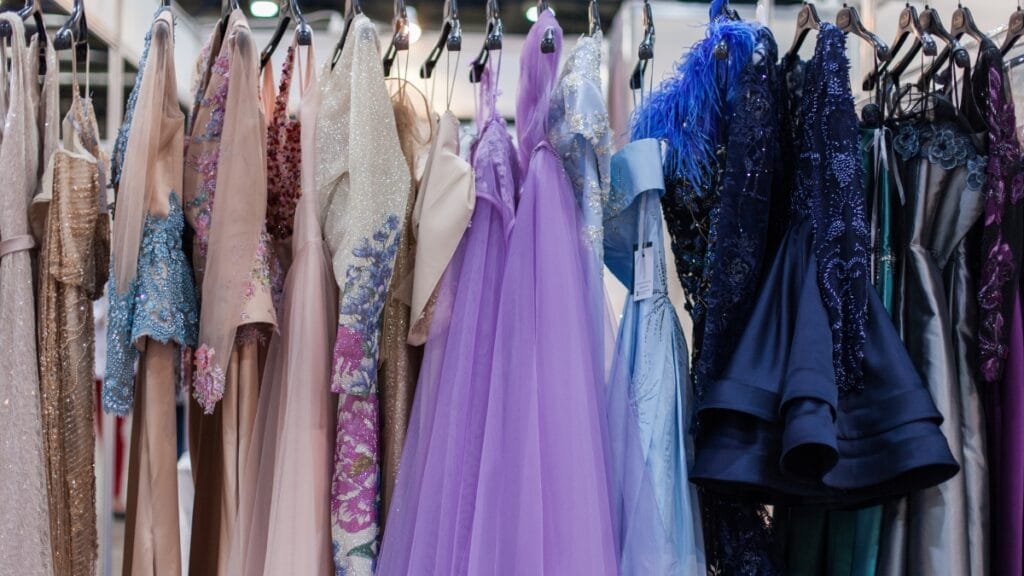 A selection of plus size evening gowns on hangers, showcasing different styles and colors