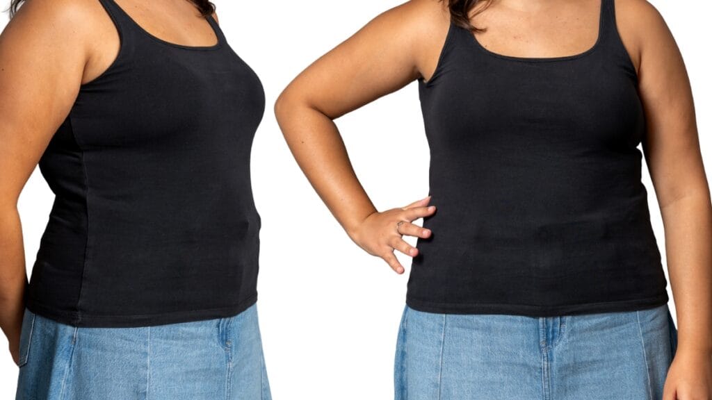 Plus size woman modeling a simple black exercise tank top, smiling and ready for action