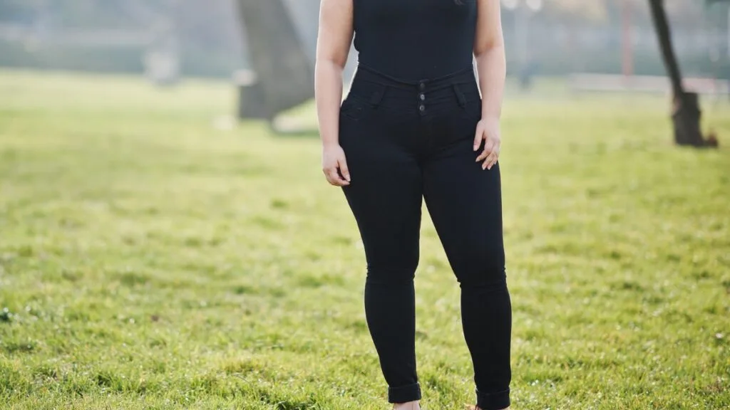 A fashionable plus-size woman dressed in a professional grey suit and matching pants, perfect for casual or semi-formal funeral settings. Her confident stride reflects the style and sophistication of plus size funeral outfit pants