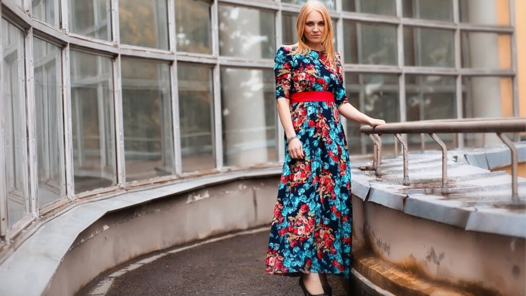 Size 12 women's floral dress in vibrant colors, featuring a red belt and a modern urban backdrop.