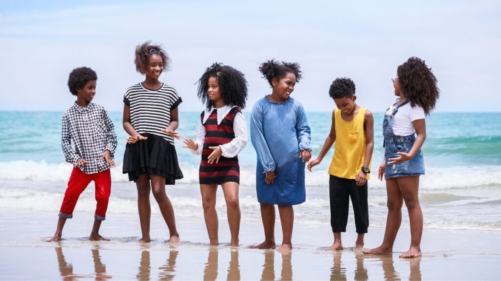 Trendy kids outfits for boys and girls at the beach, showcasing summer fashionA group of children in size 8 kidswear enjoying a day at the beach, dressed in fashionable summer outfits
