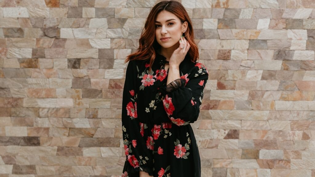 Close-up of a woman in a velvet floral dress, highlighting the intricate floral details.