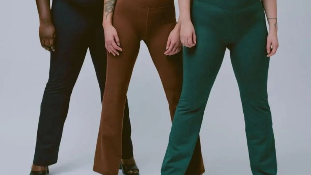 "Three individuals standing side by side, each wearing a pair of plus-size flare yoga pants in different colors: black, brown, and green. The pants are tailored to fit comfortably, and each person has their own unique body type, showcasing the versatility and flattering fit of the pants."