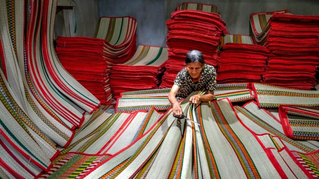 A stack of multicolored woven mats in a workshop, ready for use in decoration or furniture