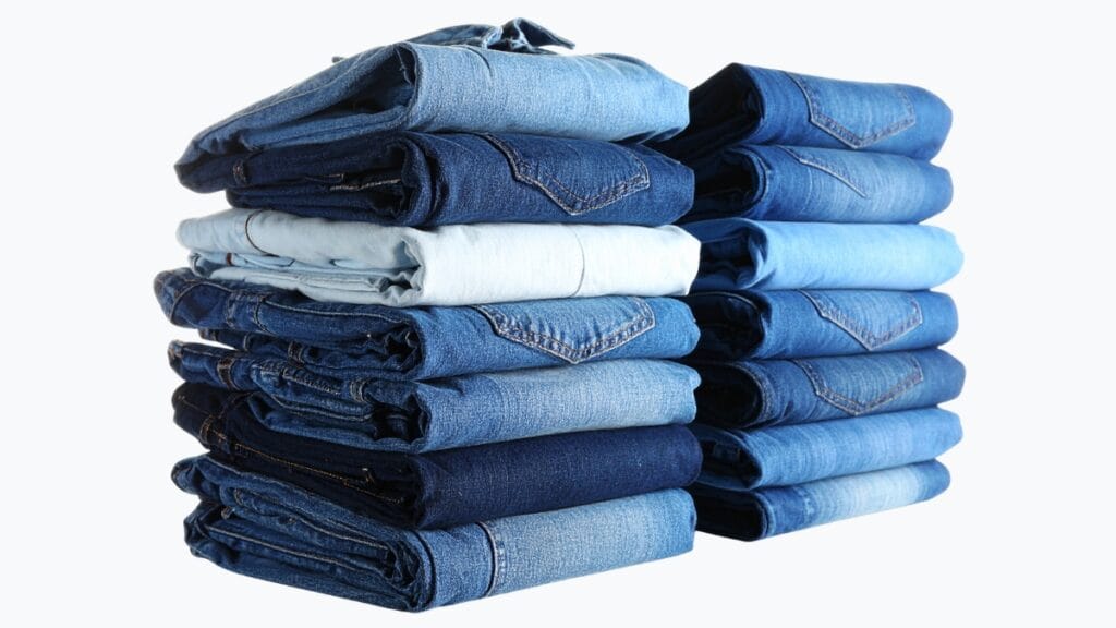 Denim vs Cotton: Stacked denim jeans in different shades of blue, showcasing denim's color diversity