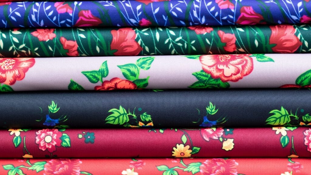 A selection of floral cotton fabrics in various colors, showcasing different types of cotton materials ideal for creating beautiful garments