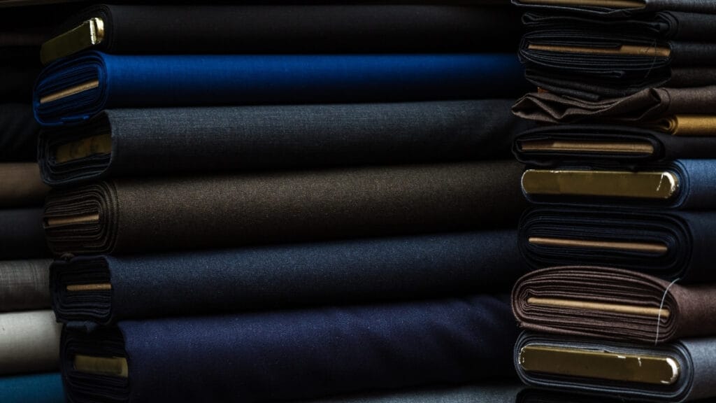 Different types of cotton materials with pictures of neatly folded dark-colored fabrics