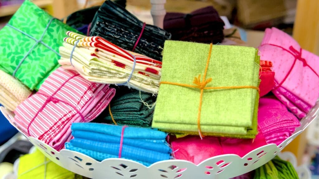 Various colorful fabric textile products stacked neatly, showcasing a range of textures and colors